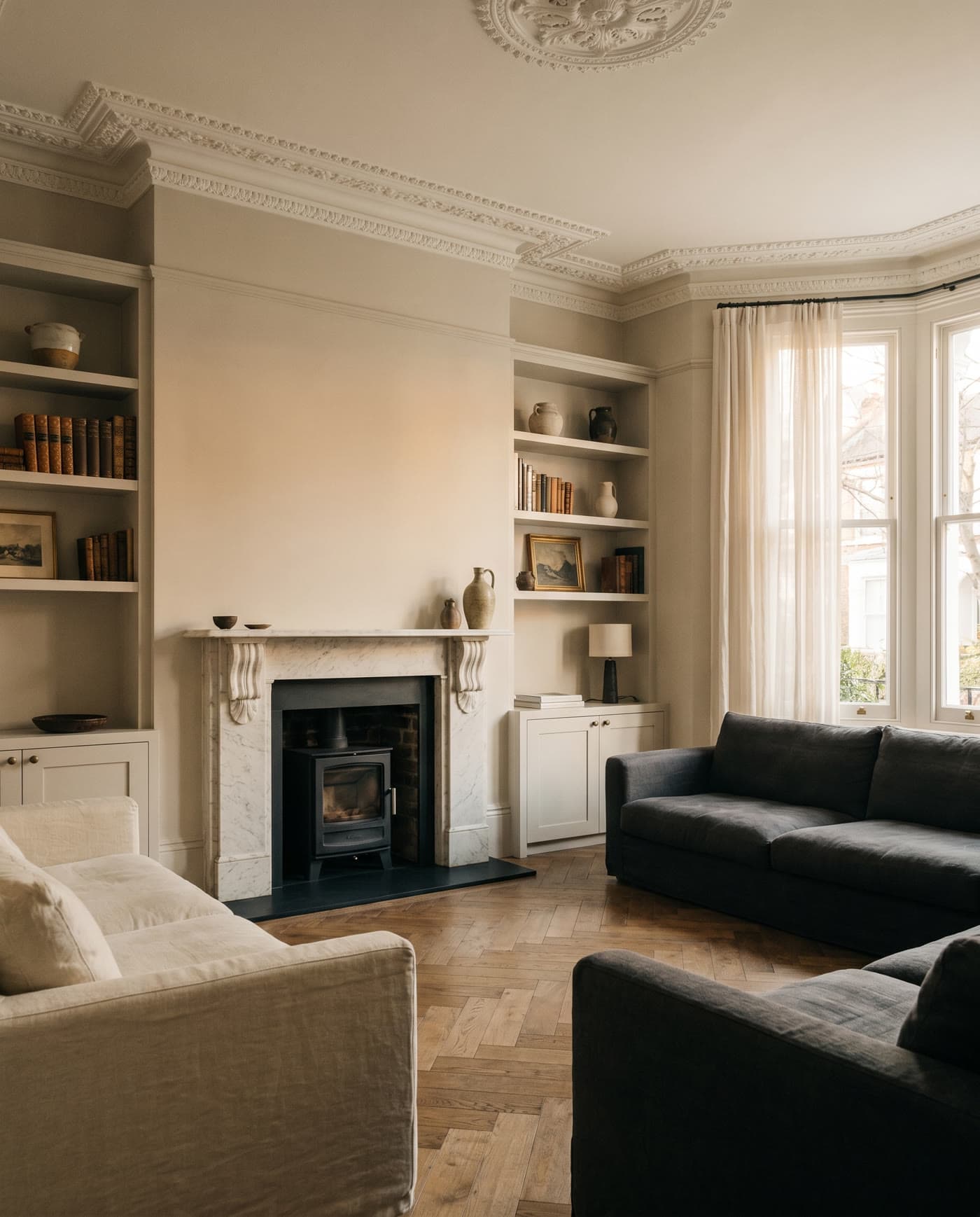 A renovated open-plan living room with layered lighting and a calm material palette